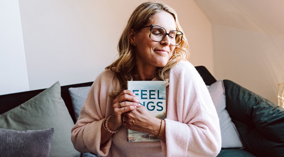 En lycklig författare som håller sin första bok i sina händer